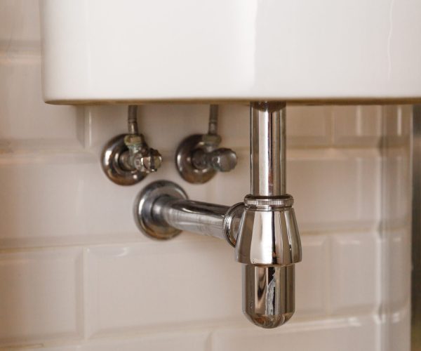 Basin siphon or sink drain in a bathroom, clean.