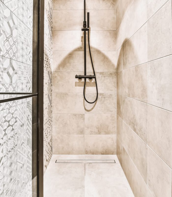 Luxurious shower cabin interior with black faucet Luxurious shower cabin interior with black faucet and beige tile